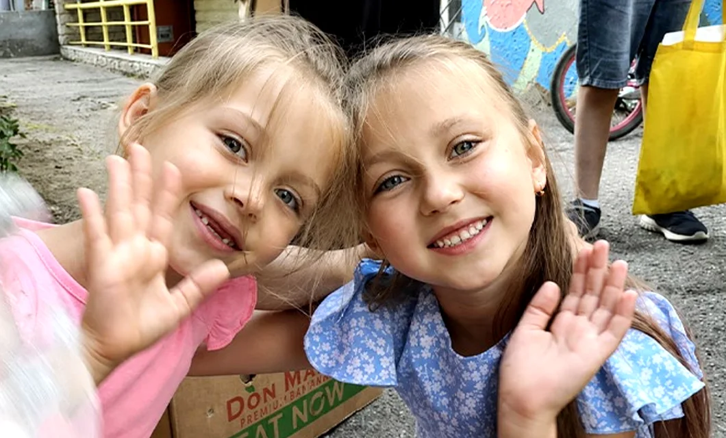 2 ukrainian girls smiling and waving